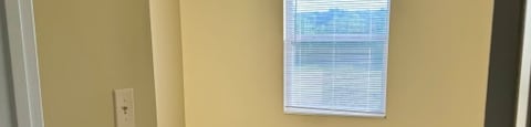 an empty room with carpet and a window