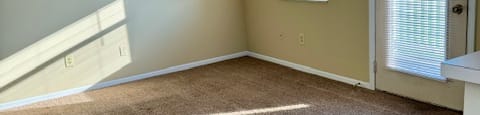 an empty room with carpet and a door