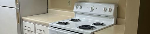 a kitchen with white cabinets and a stove and a refrigerator