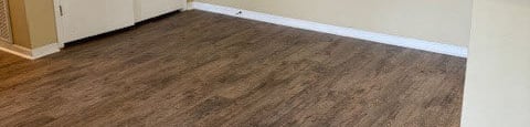 an empty living room with wood floors and a white door
