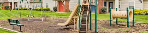 a playground with a slide and monkey bars in front of a row of houses