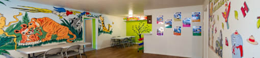 a dining room with a large mural on the wall and tables and chairs