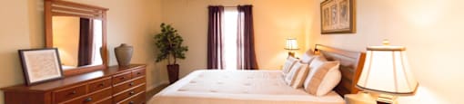 a bedroom with a large bed and a ceiling fan