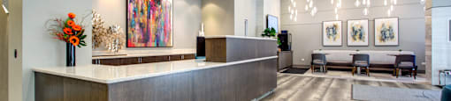 the lobby of a hotel with a reception desk and chairs