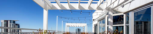 a roof deck with tables and chairs and a view of the city