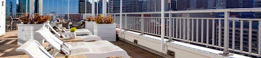 a roof deck with white lounge chairs and a view of the city