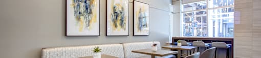 a dining room with tables and chairs and art on the wall