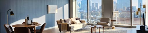 Living toom with floor to ceiling windows with a view of downtown