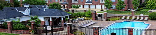 Luxury apartments with brick exteriors, scenic views, attached garages, swimming pool, poolside lounge chairs, and grilling station in Urbandale Iowa