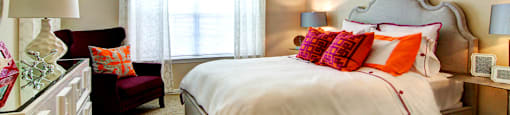 Spacious bedroom with walk-in closet and ceiling fan at Tuscany Apartments in Houston.