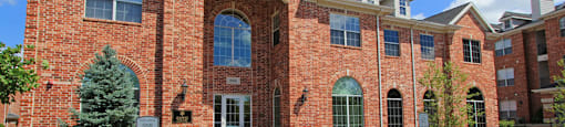 Luxury apartments with red brick exterior and lush landscaping at TurtleCreek apartments in West Des Moines, Iowa