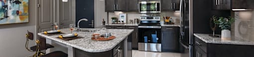 Luxury apartments with spacious floor plan, granite countertops, stainless steel appliances, built-in wine rack, kitchen island, and porcelain tile floor at Xenia Apartments in Golden Valley, Minnesota