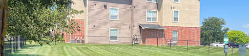a dog running in the grass in front of a house