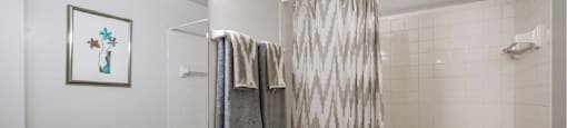 Spacious bright white bathroom with extra cabinet and storage space at Woodlake on the Bayou Apartments in Houston.