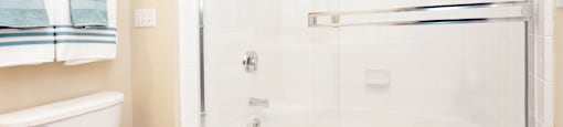 Luxury bathroom with tiled floors, glass shower, and oval soaking tub at Rockledge Oaks Apartments in Lincoln, Nebraska