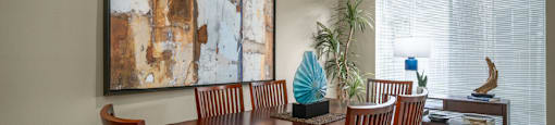 Spacious dining area with oversized windows, lots of natural light, and gray painted walls at Woodlake on the Bayou Apartments