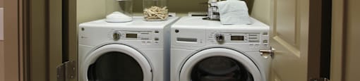 Luxury apartments with full size front loading washer and dryer with cabinet space above at Tuscany Walk Apartments in Houston.