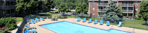 Apartments in Lincoln, Nebraska with two swimming pools, scenic views, lots of trees, poolside lounge chairs, and extra large sundeck