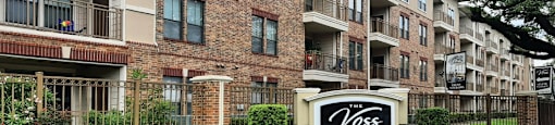 Luxury apartments with brick exteriors, two swimming pools, parking garage, and fitness center at The Voss Apartments in Houston.