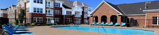 Luxury apartments with swimming pool, poolside lounges, and brick exteriors at Bellemeade Apartments in west Des Moines