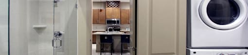 Luxury apartments with front-loading washer and dryer, glass shower, and separate oval soaking tub at Bellemeade Apartments in west Des Moines