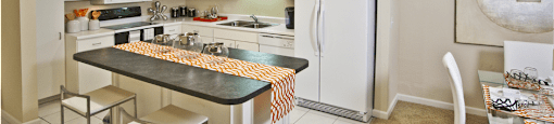 Large kitchen with lots of cabinet and counter space, white cabinets, kitchen island, and prep island at Embassy Park Apartments in Omaha, Nebraska