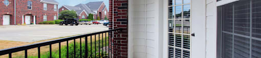 Luxury apartments with spacious balcony, red brick exterior, and beautiful landscaping at Rockledge Oaks Apartments in Lincoln, Nebraska