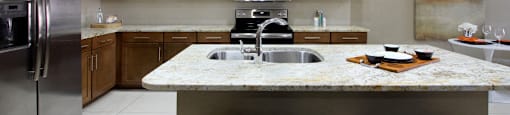 Luxury apartments with granite countertops, stainless steel appliances, built-in wine rack, kitchen island, and porcelain tile floor at Bellemeade Apartments in west Des Moines