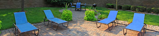 Luxury apartments with lush landscaping, picnic area, pool-side lounge chairs, park-like setting, and scenic views at Lenox Village Apartments in Lincoln, Nebraska