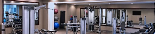Luxury apartments with huge fitness center with multiple varieties of workout machines and equipment at Tuscany Walk Apartments in Houston Texas.