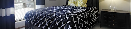 Spacious master bedroom with walk-in closet, master bathroom, and gray wall color at The Vanderbilt Apartments in Omaha, Nebraska