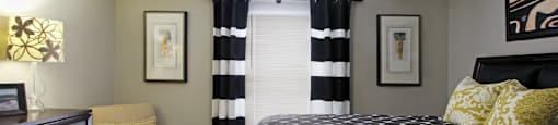 Spacious master bedroom with walk-in closet, master bathroom, and gray wall color at The Vanderbilt Apartments in Omaha, Nebraska