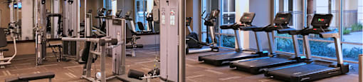 Luxury apartments with huge fitness center with multiple varieties of workout machines and equipment at Tuscany Walk Apartments in Houston Texas.