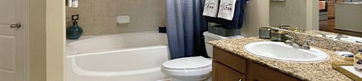 Spacious luxury bathrooms with granite slab vanity tops at The Voss Apartments in Houston.