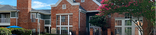 Luxury apartments with two resort-style swimming pools with fountain, poolside lounge chairs, and beautiful landscaping in Dallas.