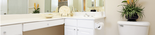 Luxury apartments with spacious bathrooms with tiled floors, oval soaking tubs, built-in vanity, cultured marble vanity, glass shower and white cabinets in at Saddlebrook apartments in Urbandale Iowa