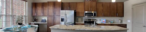 Luxury apartments with spacious kitchen, granite countertops, stainless steel appliances, built-in wine rack, kitchen island, front-loading washer and dryer and porcelain tile floor at Bellemeade Apartments in west Des Moines