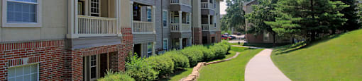 an exterior view of an apartment building with a sidewalk