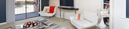 Spacious living room with colored feature wall and built-in shelves at Embassy Park Apartments in Omaha, Nebraska