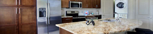 Luxury apartments with spacious kitchen, granite countertops, stainless steel appliances, built-in wine rack, kitchen island, front-loading washer and dryer and porcelain tile floor at Bellemeade Apartments in west Des Moines