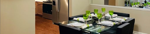 Spacious dining room with 9-foot ceilings, mirror accent wall, stainless steel appliances, side-by-side refrigerators at The Lanesborough Apartments in Houston.