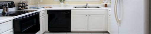 Luxury apartments with bright white kitchen, u-shaped kitchen, white cabinets, and side-by-side refrigerator at TurtleCreek apartments in West Des Moines, Iowa