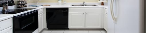 Spacious u-shaped kitchen, luxury apartments with bright white kitchen and side-by-side refrigerator at Saddlebrook apartments in Urbandale, Iowa