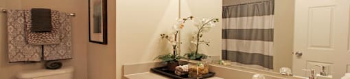 Spacious bathroom with lots of cabinet space, soaking tub and shower, and porcelain tile floors at Breckenridge Apartments in Omaha, Nebraska