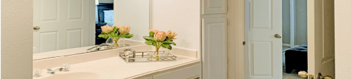 Spacious bathroom with cultured marble vanity, spacious linen cabinet, white cabinets, and built-in vanity at The Lanesborough Apartments in Houston.
