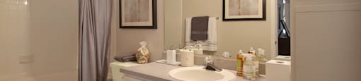 Spacious bathroom with lots of cabinet space, soaking tub and shower, and porcelain tile floors at Breckenridge Apartments in Omaha, Nebraska