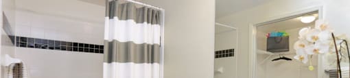 Spacious bright white bathroom with oversized garden tub and built-in vanity at Village on the Parkway Apartments.