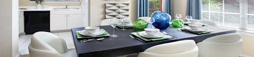 Spacious dining room with oversized windows, u-shaped kitchen with white cabinets, and side-by-side refrigerator at TurtleCreek apartments in West Des Moines, Iowa