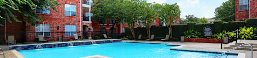 Luxury apartments with large swimming pool, multiple swimming pools, spa, and large sundeck with poolside lounge chairs at The Lanesborough Apartments in Houston