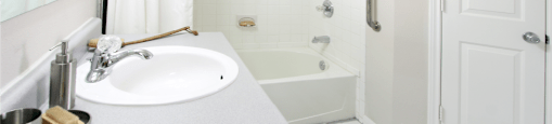 Spacious bathroom with white cabinets, linen closet, extra cabinet space, soaking tub and tiled shower at Breckenridge Apartments in Omaha, Nebraska